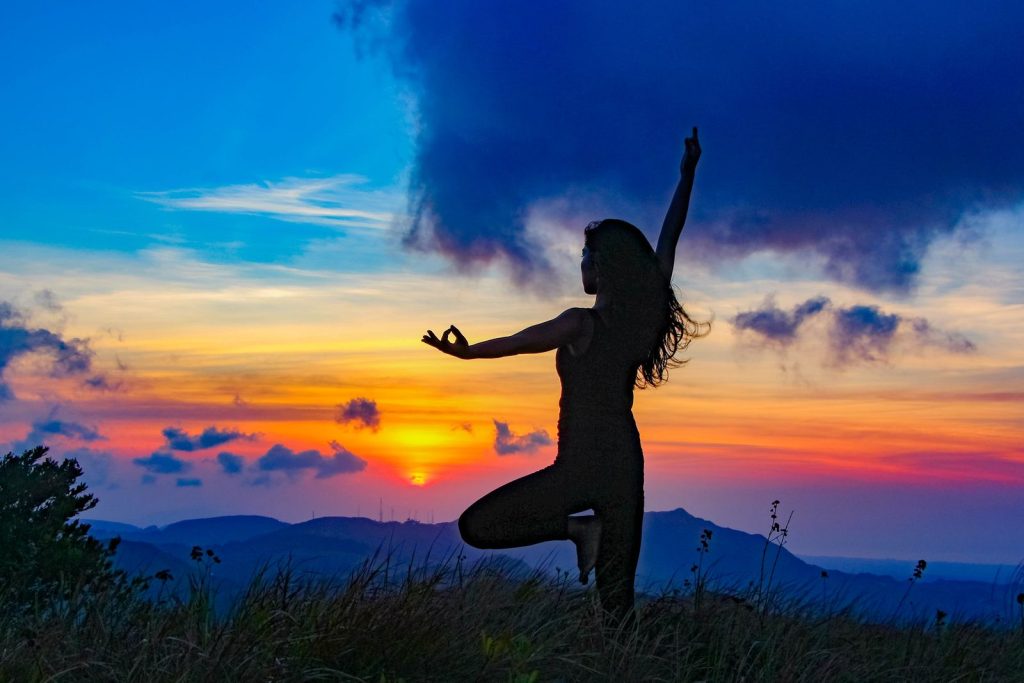 Yoga-Silhouette bei Sonnenuntergang – Frau in der Baumspose
