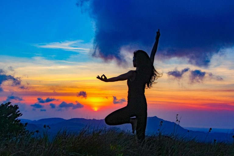 Yoga-Silhouette bei Sonnenuntergang – Frau in der Baumspose